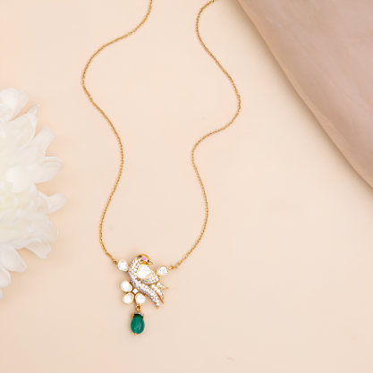 Gold-plated floral pendant necklace with white stones, pearl accents, and a green gemstone drop.