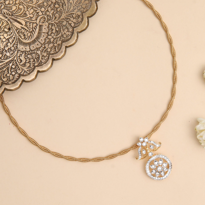 Gold-tone silver necklace with a round floral pendant.